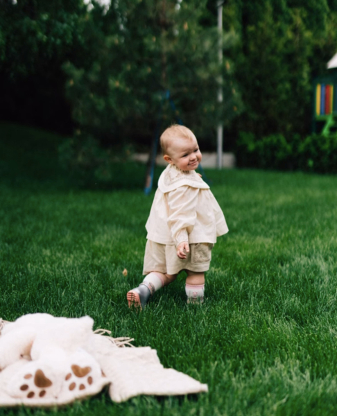 Дружина Усика з однорічною дочкою попозували на травичці в ніжних лляних сукнях. Фото