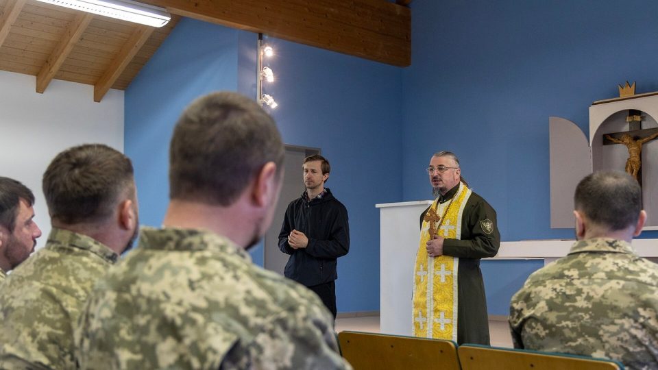 Український військовий капелан у ризі молиться разом із військовими під час навчального курсу