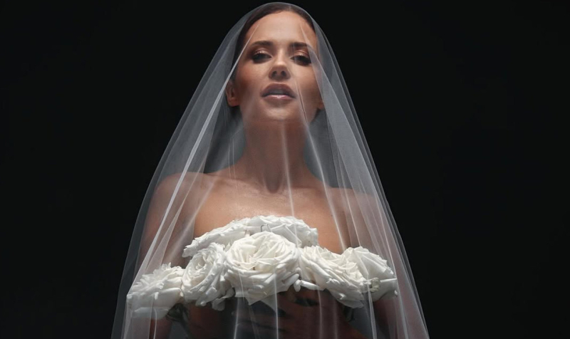 Оголена Денисенко у вельоні до підлоги прикрила принади квітами. Фото